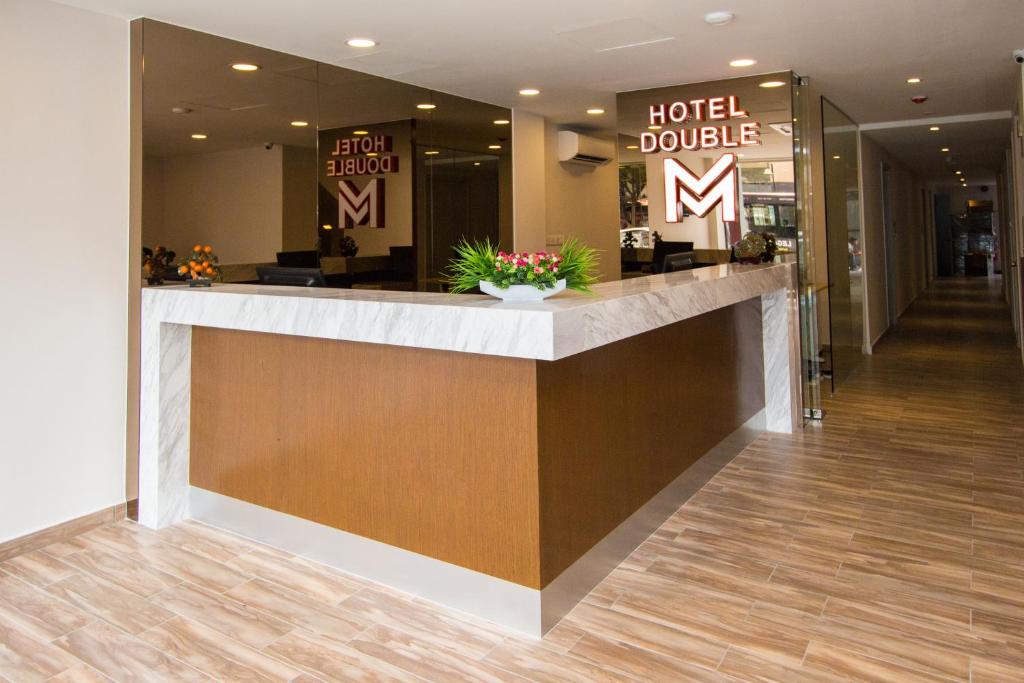 a hotel lobby with a reception counter and a hotel double sign at Double M Hotel @ Kl Sentral in Kuala Lumpur