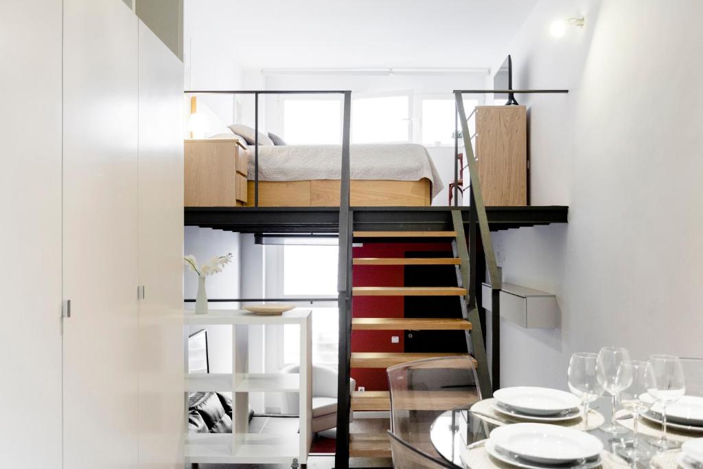 マドリードにあるOdonell Loft by Flatsweethomeの二段ベッド1組、ダイニングテーブルが備わる小さなアパートメントです。