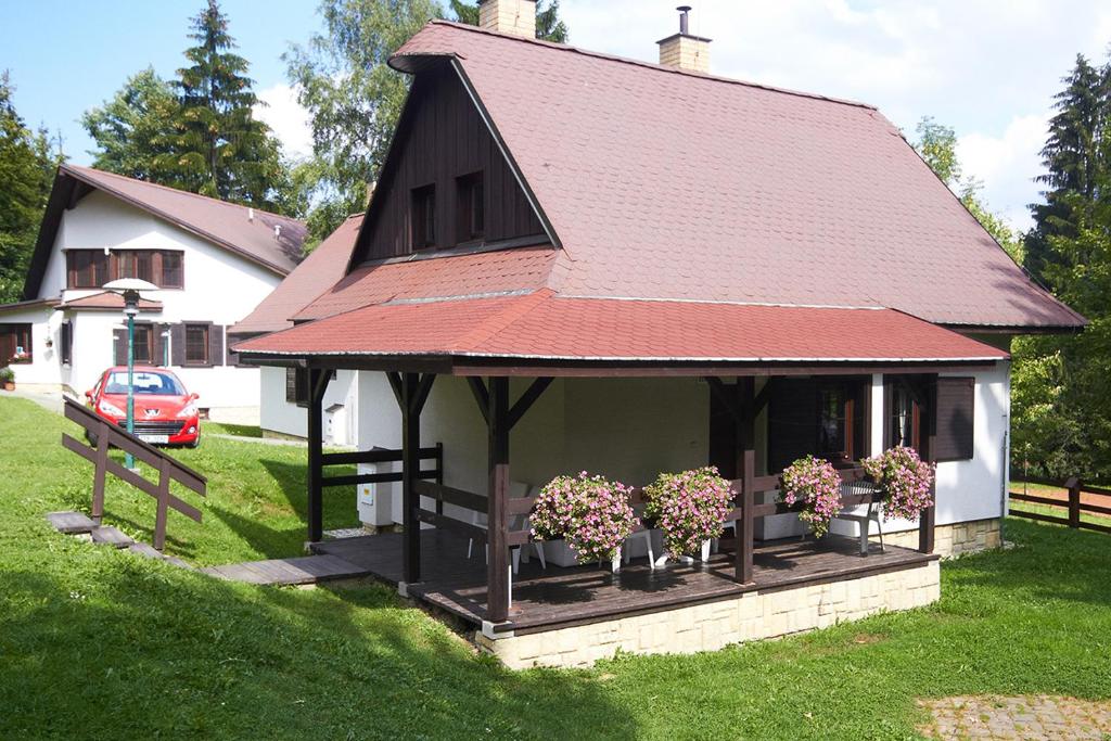 a small house with potted plants in the yard at Chalupy Na Rališce in Horní Bečva