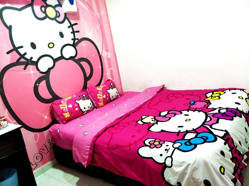 een slaapkamer met een roze bed met tekenfilmdieren erop bij branded hotel in Melaka