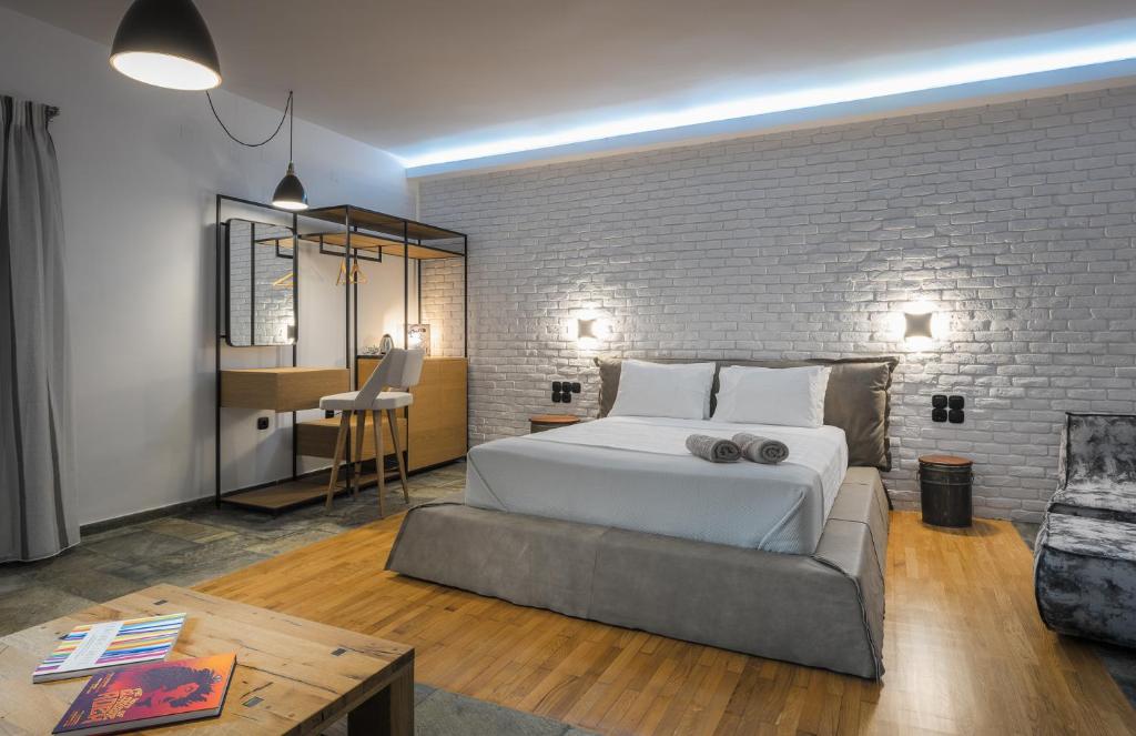 a bedroom with a white bed and a brick wall at The Secret Boutique Hotel in Lefkada Town