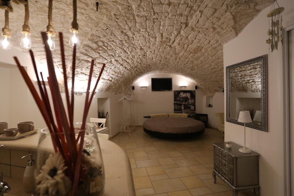 uma sala de estar com uma cama num quarto com um tecto de pedra em Casa Vacanze Il Rifugio Del Principe em Putignano