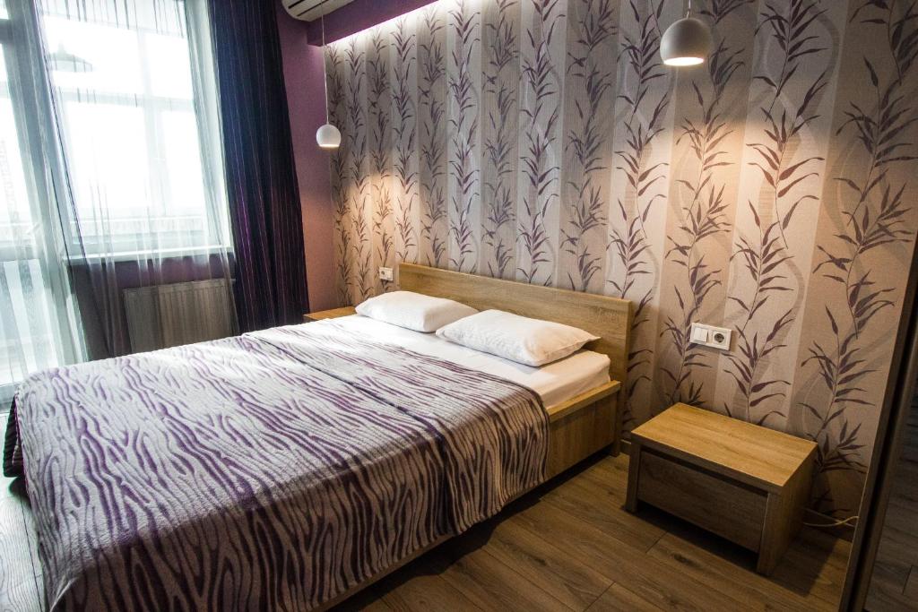 a small bedroom with a bed and a window at Solo Apartment Dragomanova in Kyiv
