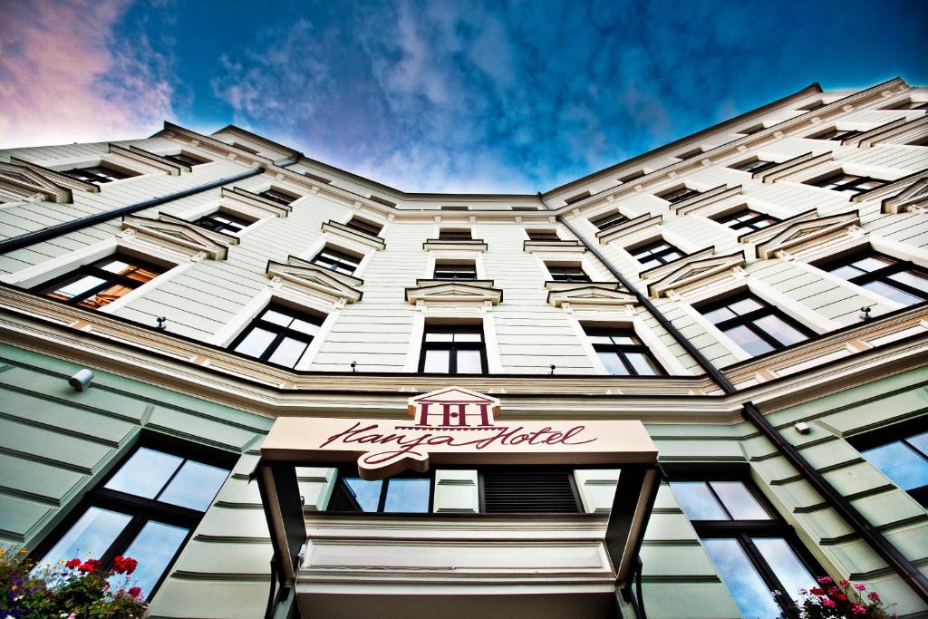 a large white building with a hotel sign on it at Hanza Hotel in Rīga