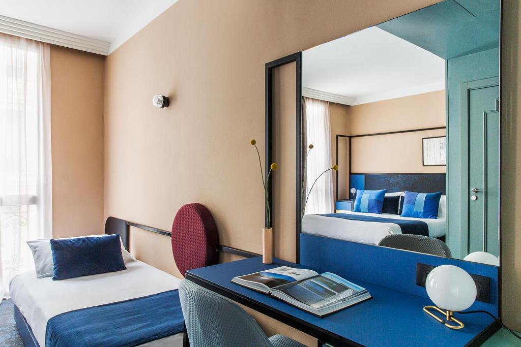 Кровать или кровати в номере Hôtel les Cigales