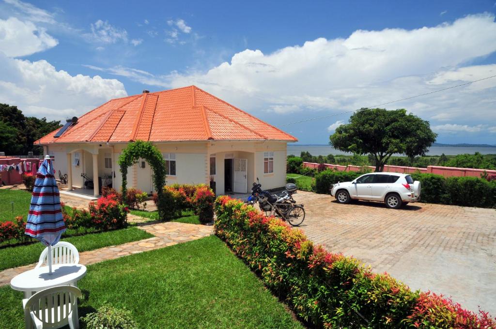 a house with an orange roof and a car parked at Victoria Lake View Guesthouse & Safaris in Entebbe