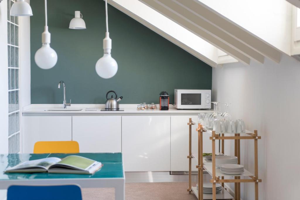 a kitchen with white cabinets and a blue wall at Brera Apartments in Garibaldi in Milan