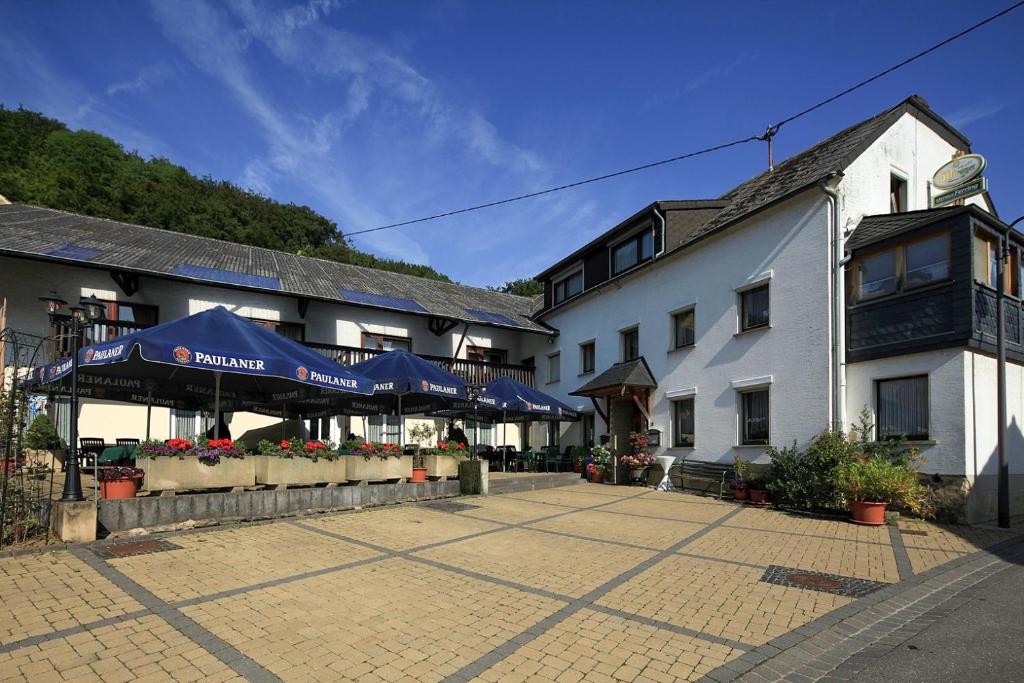 a building with blue umbrellas in a courtyard at Gasthaus-Pension Ferring in Minden