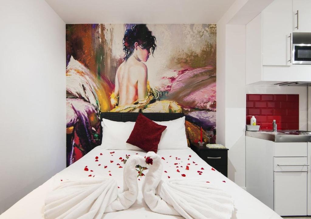 - une chambre avec un lit orné d'une peinture murale dans l'établissement Wembley Park Hotel, à Londres