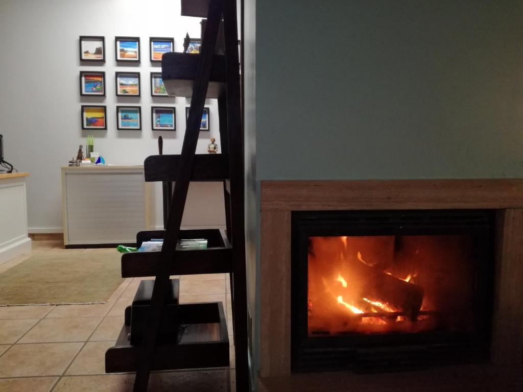 a fireplace in a living room with a fire at Hotel Rural Cuartamenteru in Llanes