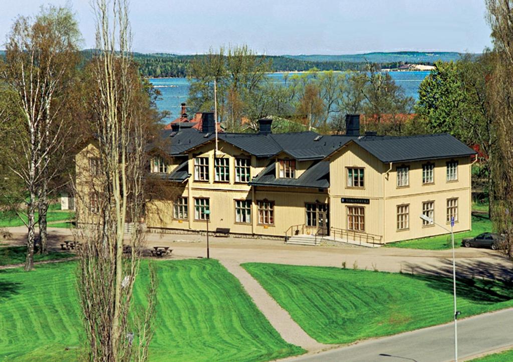 a large yellow house with a black roof at Karlsborgs vandrarhem och B&B in Karlsborg