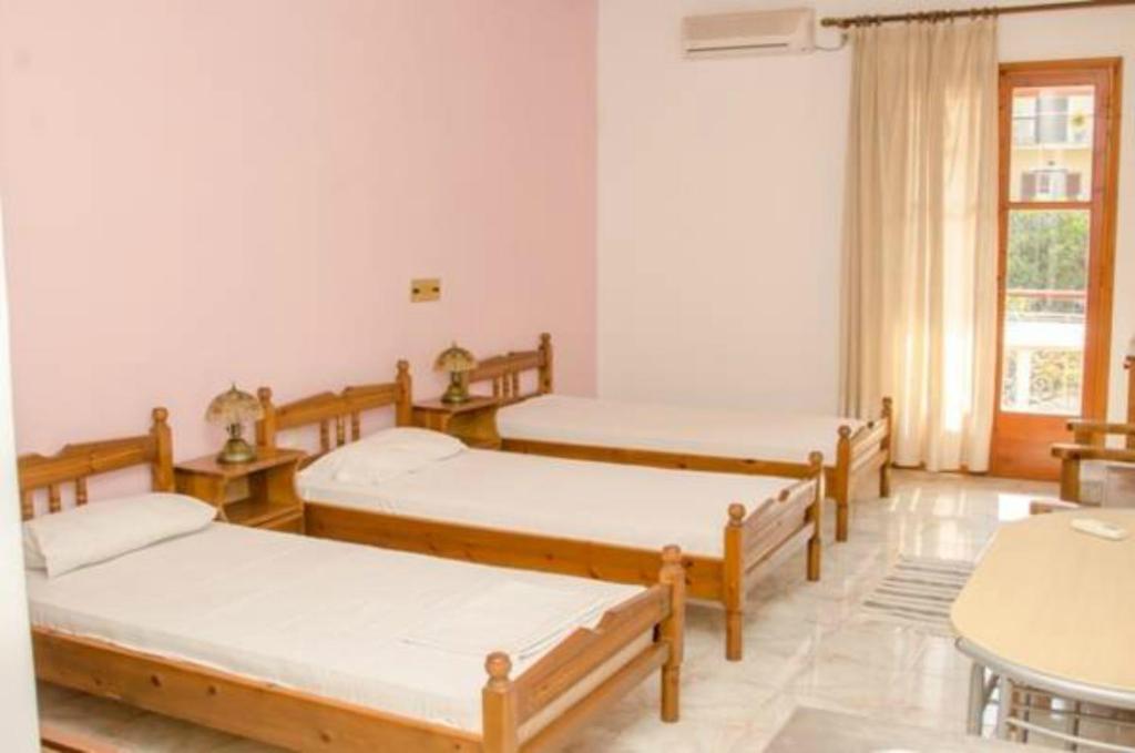 a group of four beds in a room at Kristi in Póros Kefalonias