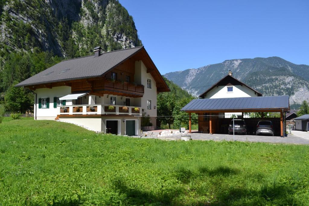 uma casa grande com garagem ao lado de uma montanha em Ferienwohnung Zauner em Hallstatt