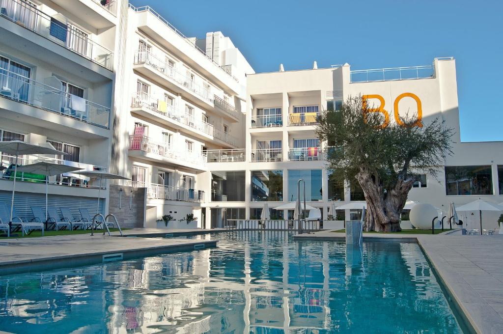 a swimming pool in front of a building at BQ Bulevar Peguera- Adults Only in Paguera