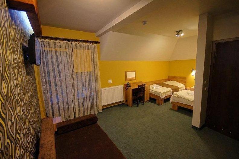 um quarto de hotel com duas camas e uma secretária em Zajazd Pod Caryńską em Ustrzyki Górne