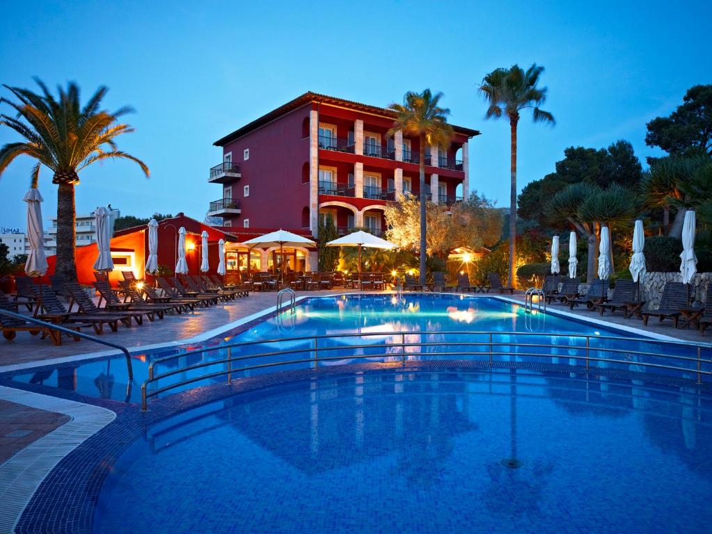 a large swimming pool in front of a hotel at Hotel Cala Sant Vicenç - Adults Only in Cala de Sant Vicent