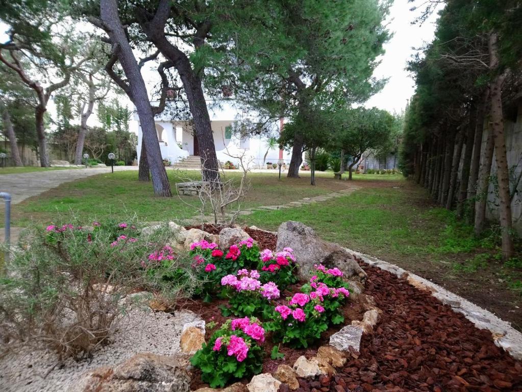 un letto a fiori con fiori rosa in un parco di Villa Memia a Lendinuso