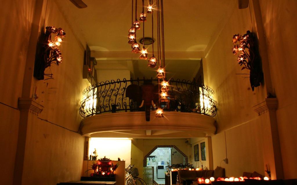 a hallway with a balcony with a chandelier and lights at Born Free Hostel in Bangkok