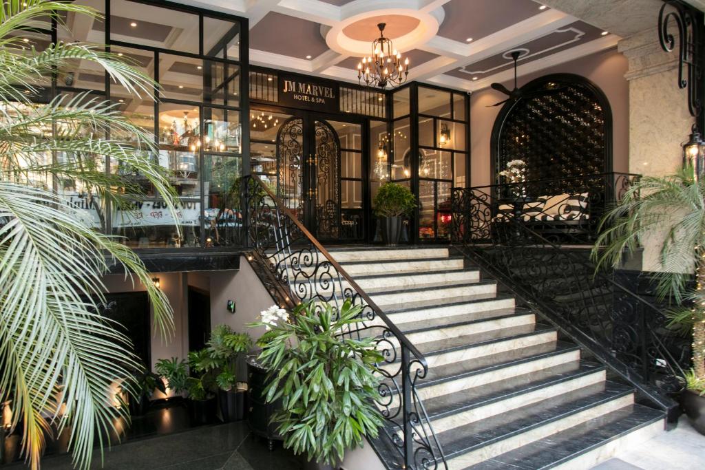 a lobby with stairs and potted plants at JM Marvel Hotel & Spa in Hanoi