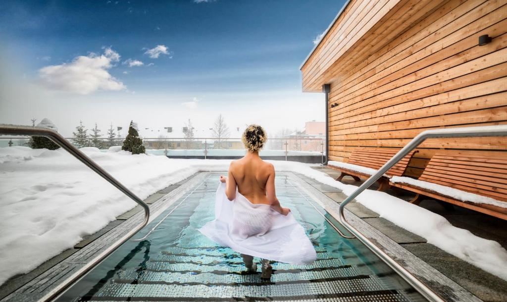 een vrouw in een trouwjurk in een bubbelbad bij Wellnesshotel Eggerwirt in Sankt Michael im Lungau