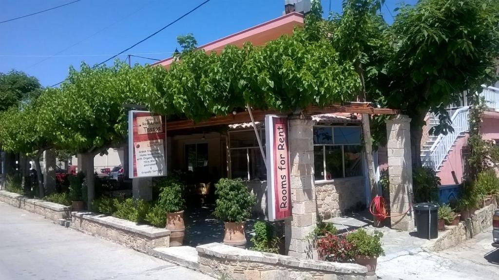 um restaurante com árvores em frente em Tassos Rooms em Kórinthos