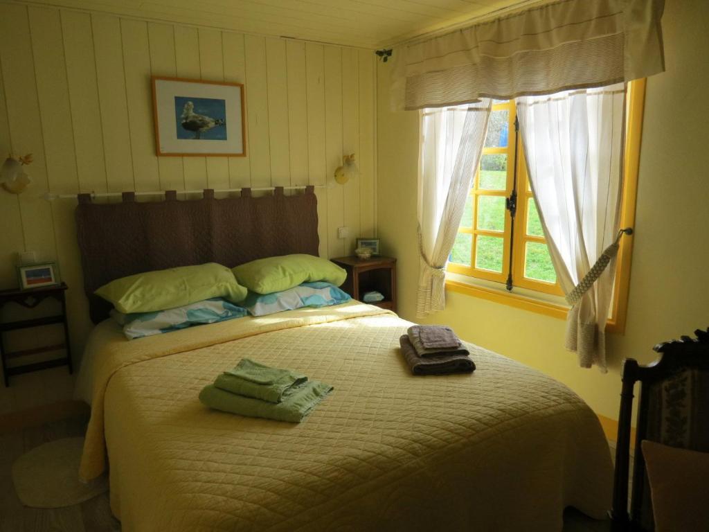 una camera da letto con un letto e due asciugamani di Le Chant Des Fees a Notre-Dame-de-Courson