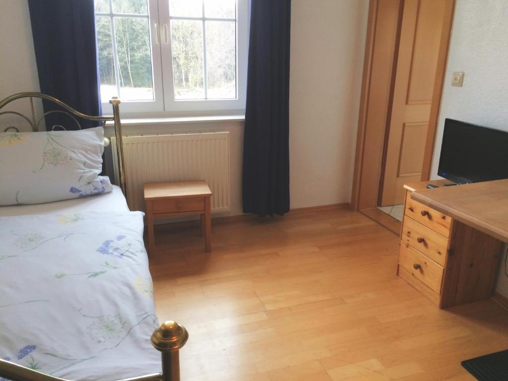 ein Schlafzimmer mit einem Bett, einer Kommode und einem TV in der Unterkunft Fuchsenlohe in Schlier