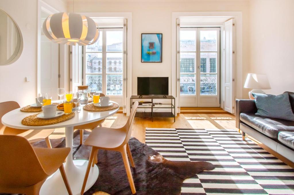 uma sala de estar com uma mesa e um sofá em Restauradores Prestige em Lisboa