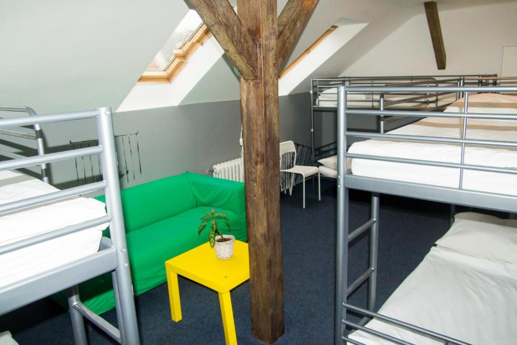 a dorm room with bunk beds and a yellow table at Hostel Franz Kafka in Prague