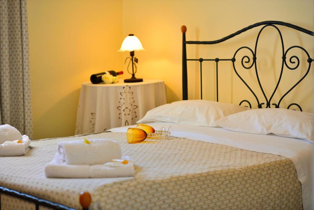a bed room with a white bedspread and two lamps at Galini Hotel in Mikonos
