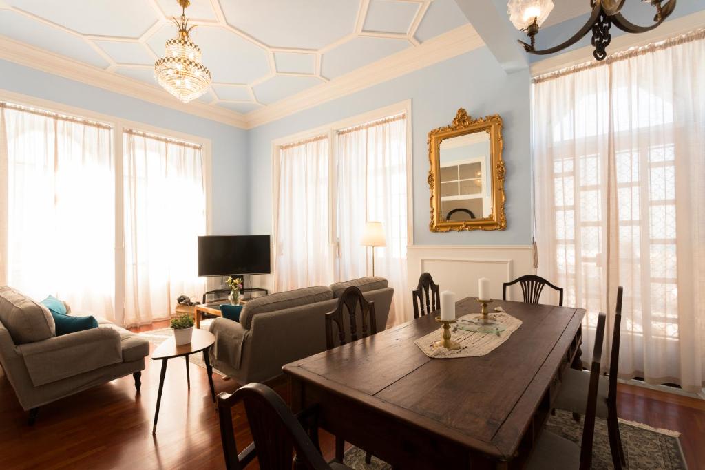 a dining room with a table and chairs and a living room at Ericeira Soul Guesthouse in Ericeira