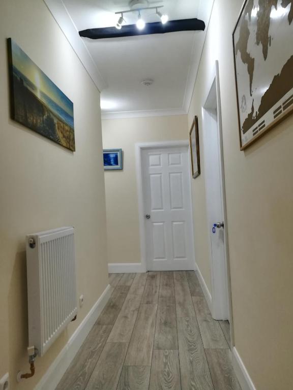 a hallway with white walls and a white door at Royal Guest House II in Viersen