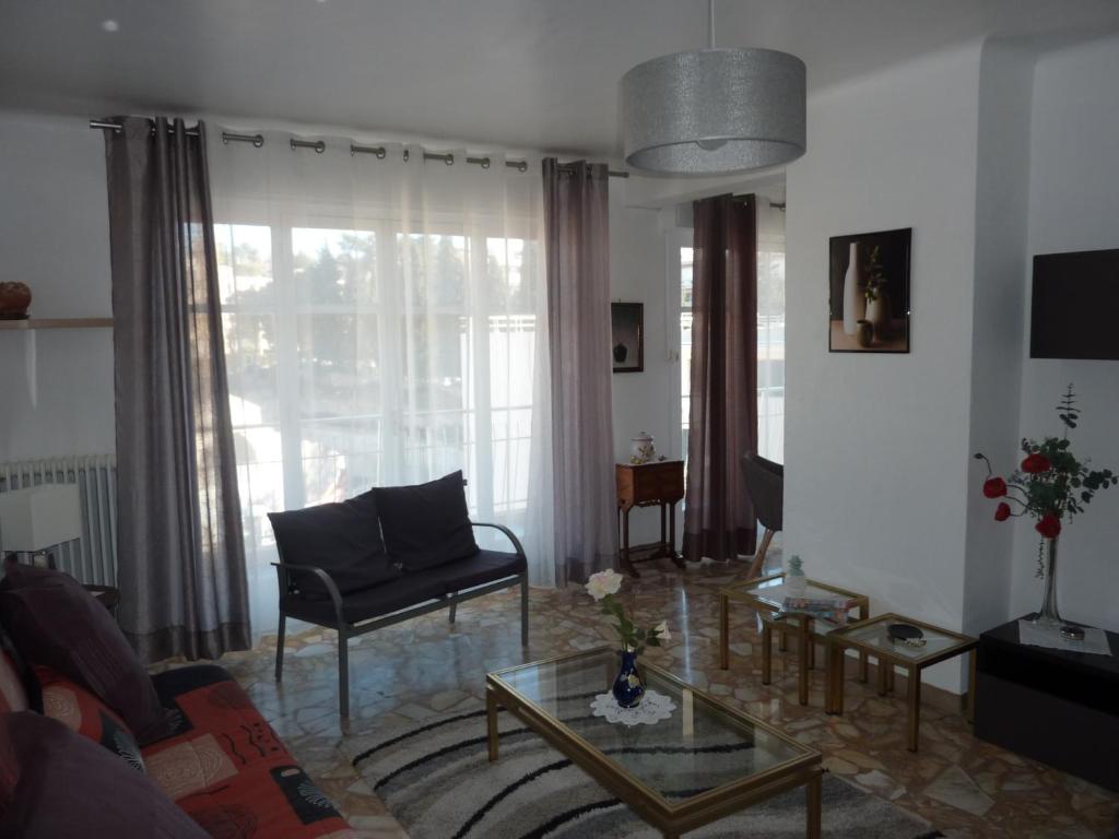 uma sala de estar com um sofá e uma mesa em Le Tanagra em Vallauris