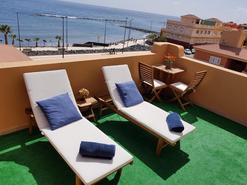 - un balcon avec 2 chaises, une table et la plage dans l'établissement ¡Amazing place!, à Puertito de Güímar