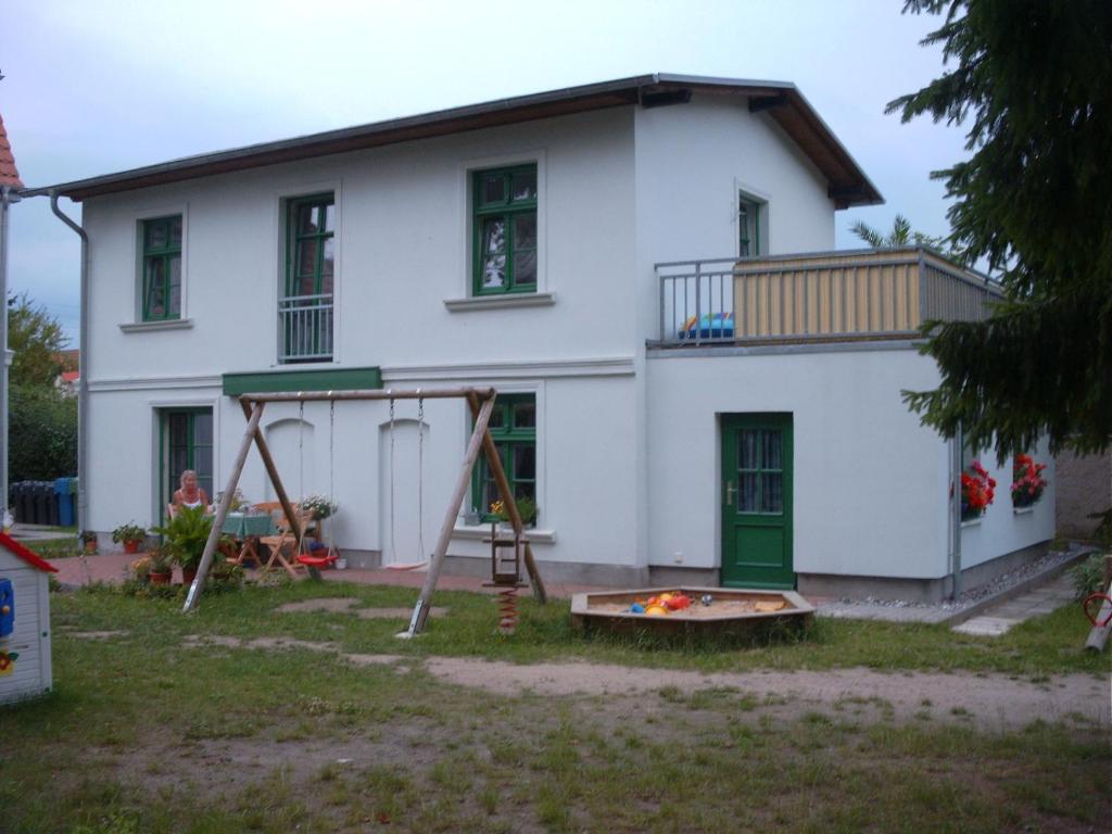 una casa con un parque infantil delante de ella en Ferienhaus Schwalbe Seebad Lubmin, en Lubmin