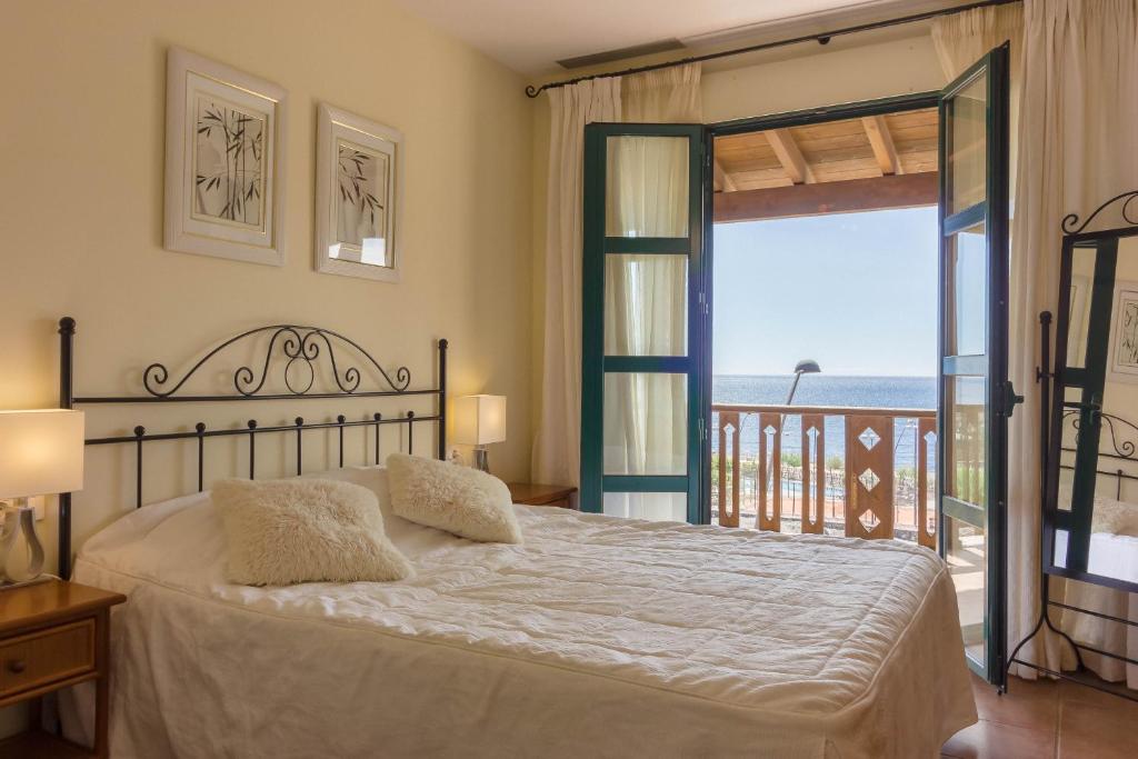 a bedroom with a bed and a view of the ocean at Okeanos Villa front line San Blas in San Miguel de Abona