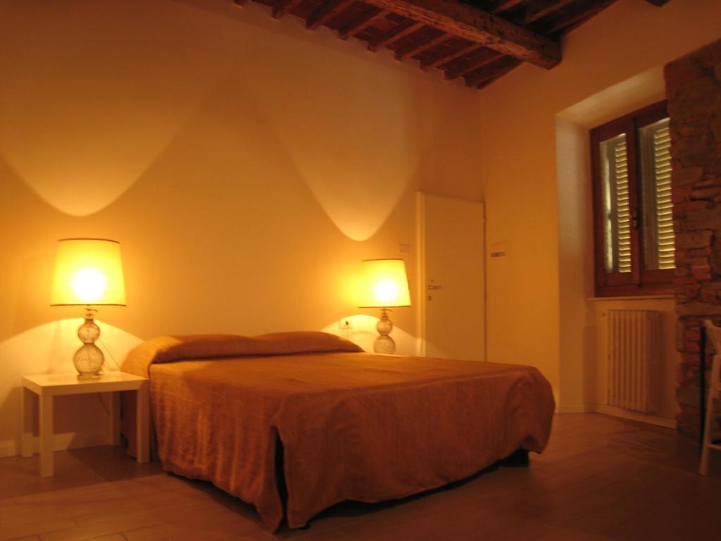 a bedroom with a bed and two lamps on two tables at Rinathos Guesthouse in Arezzo