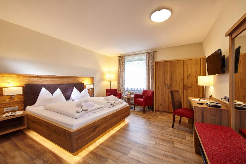 a hotel room with a bed and a desk at AURA-HOTEL Saulgrub in Saulgrub