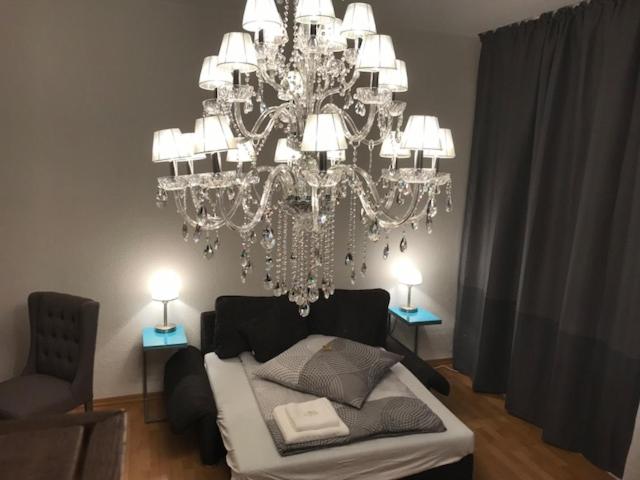 a bedroom with a chandelier and a bed and a chair at Apartment Erfurt Mitte in Erfurt