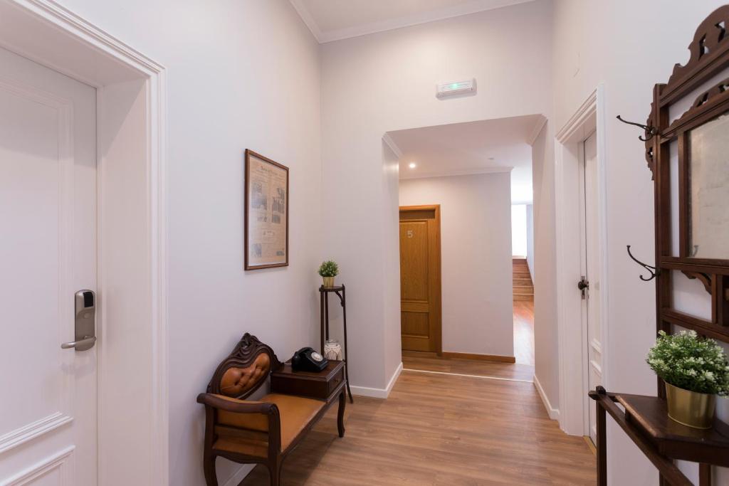 a hallway with white walls and wooden floors at Ericeira Soul Guesthouse in Ericeira