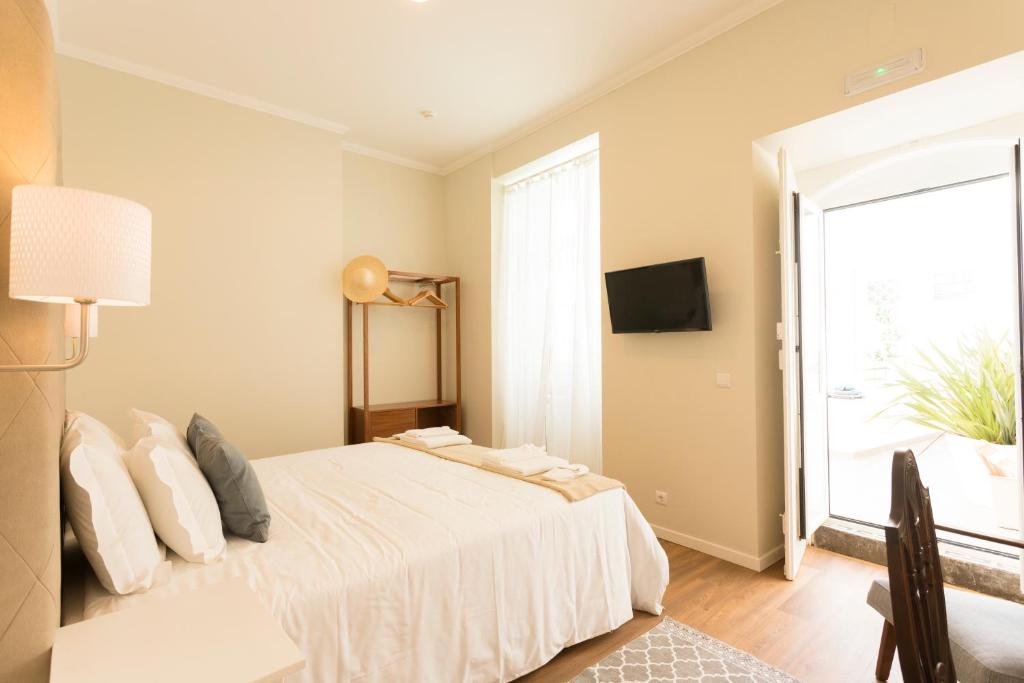 a bedroom with a white bed and a window at Ericeira Soul Guesthouse in Ericeira