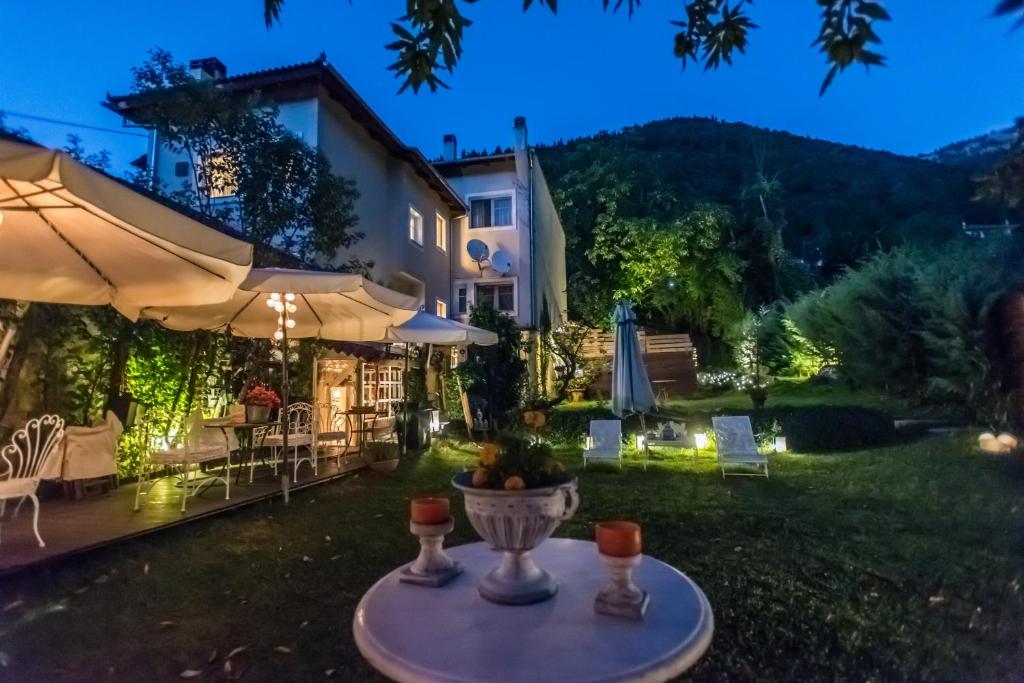 podwórko ze stołem i parasolem w obiekcie Anerada inn Suites & Spa - Pet Friendly w mieście Karpenision
