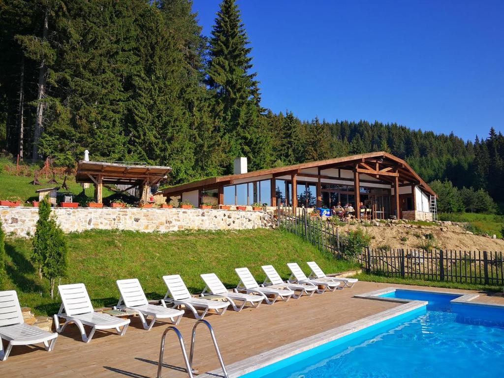a group of chairs sitting next to a swimming pool at Amampuri Village in Pamporovo