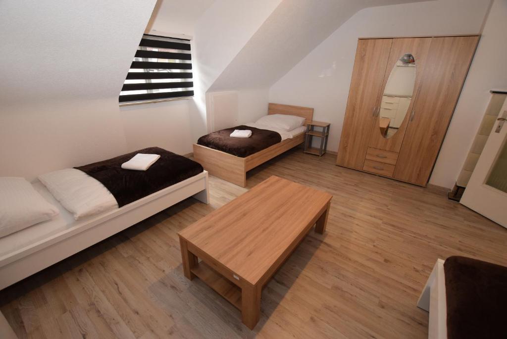 Cette petite chambre comprend deux lits et une table. dans l'établissement Apartment Hedelfingen I, à Stuttgart
