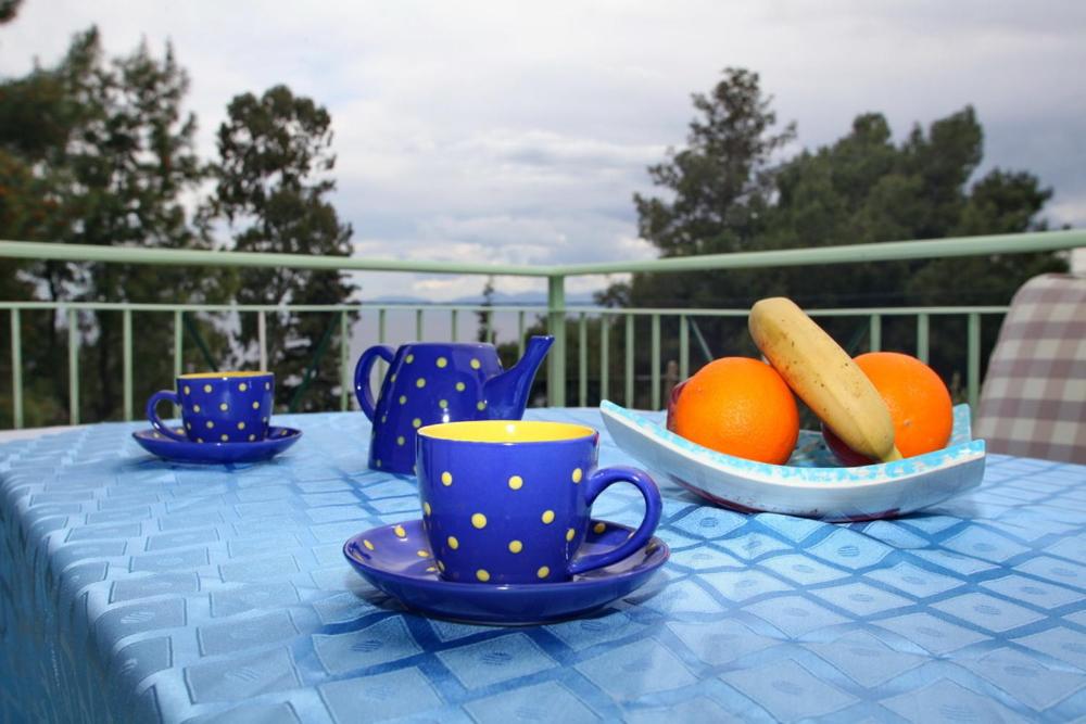 a blue table with blue cups and oranges on it at Pelagos in Stafylos