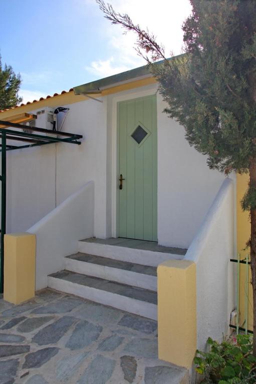 a green door on a white building with stairs at Pelagos in Stafylos