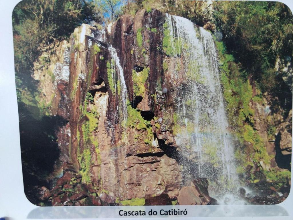 a painting of a waterfall on a mountain at Hotel Pousada Por do Sol in Protásio Alves