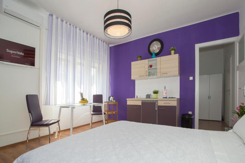 sypialnia z białym łóżkiem i fioletową ścianą w obiekcie Gaston Luxury Apartment w Splicie