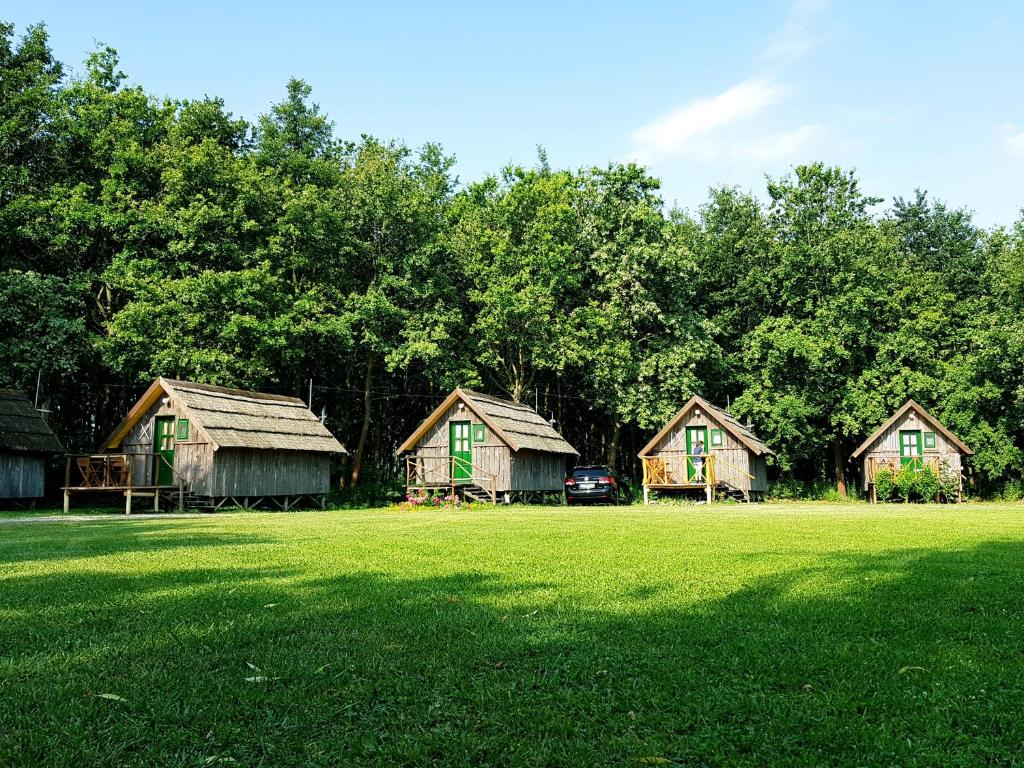 un grupo de casas en un campo con árboles en Achilles Park en Győr