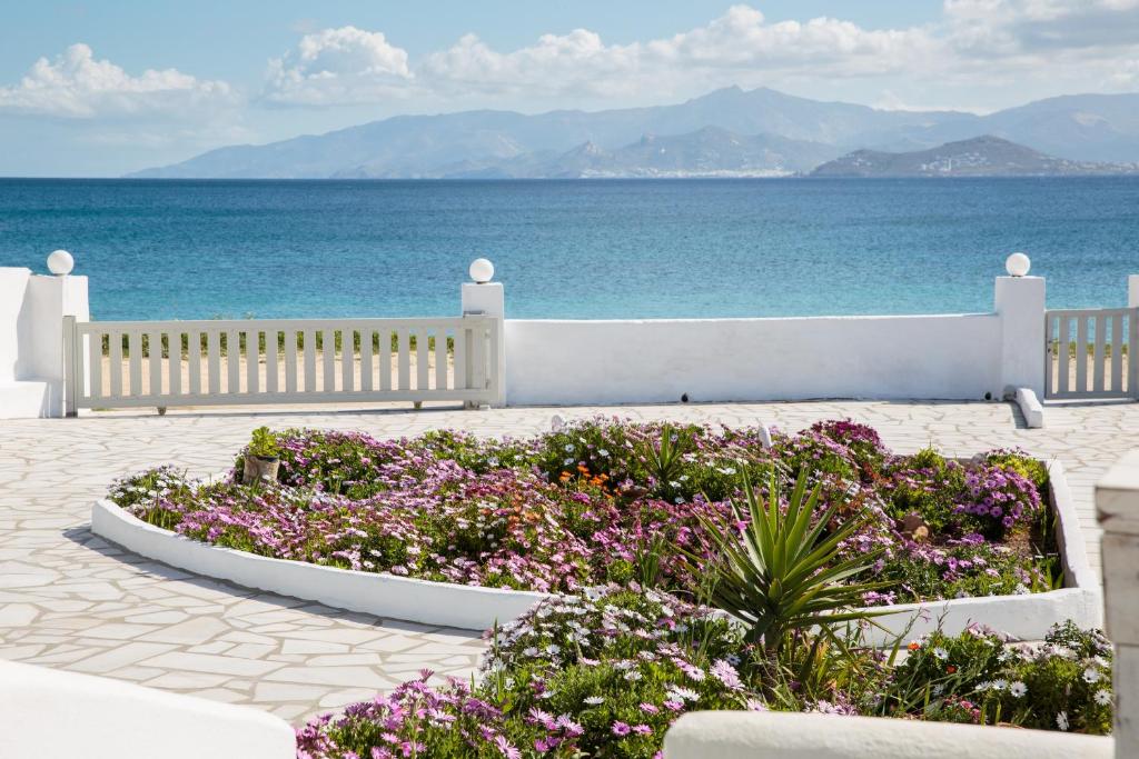 a garden with purple flowers in front of the ocean at Paradis beach home in Molos Parou